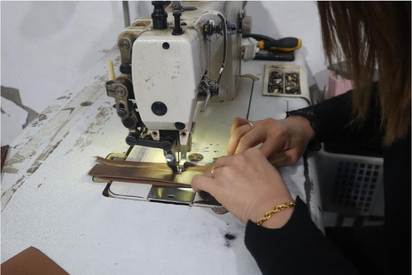 A Changrong operator stitching a bag component on an industrial sewing machine